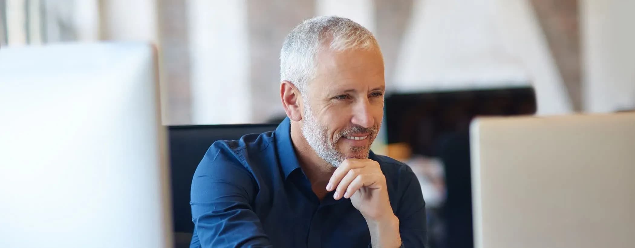 Professional recruiter reviewing candidate profiles on a computer in a modern office – Chameleoni recruitment platform.